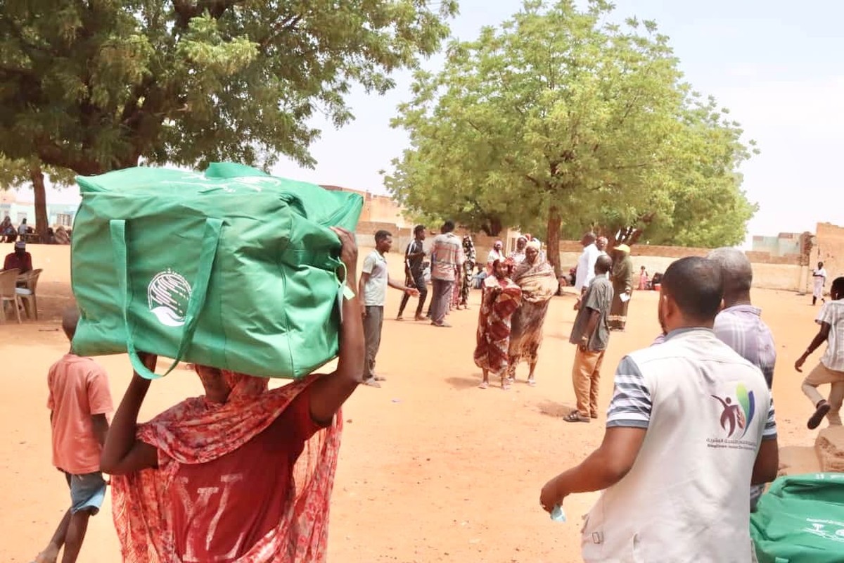 مستفيدة تحمل حقيبة إيوائية من مركز الملك سلمان للإغاثة في ولاية النيل الأبيض بالسودان