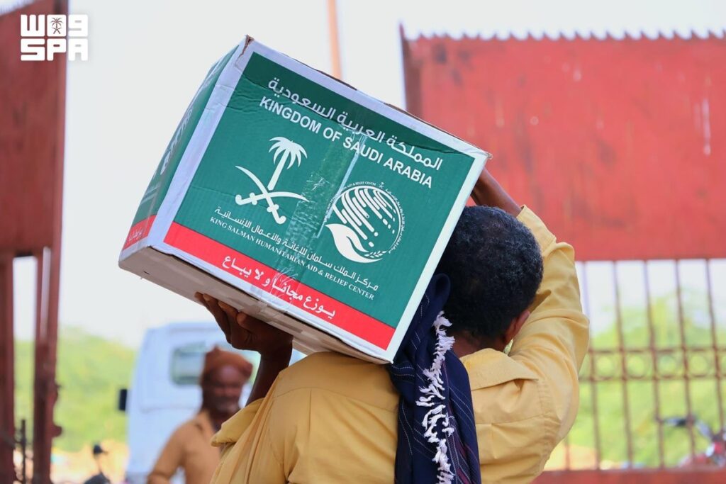 مستفيد يحمل سلة غذائية من مركز الملك سلمان للإغاثة في أبين